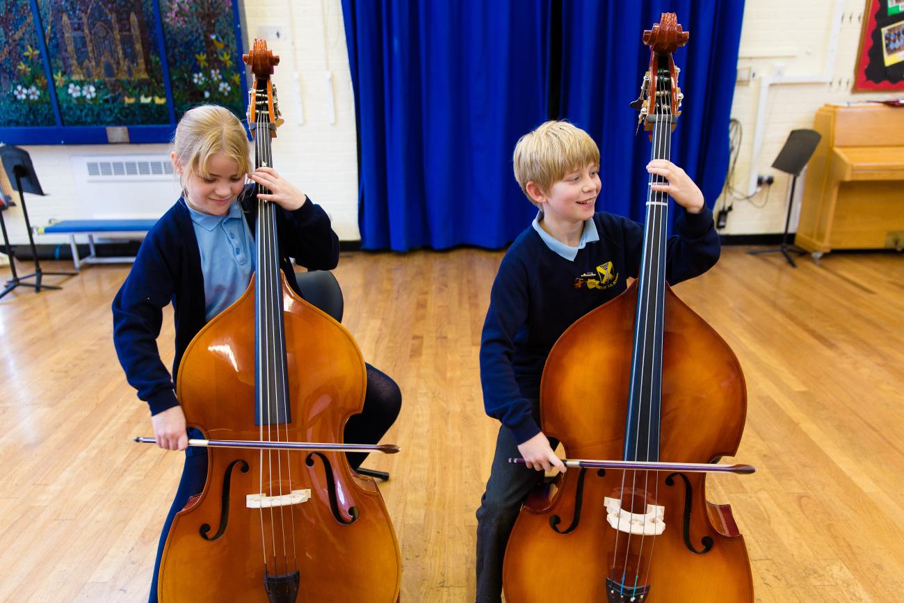 two children play double bass'