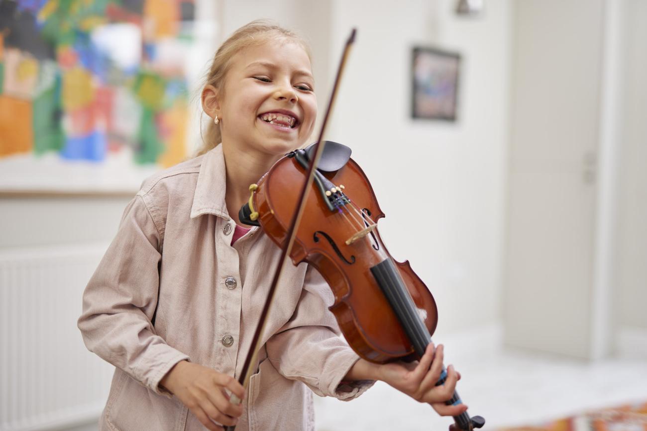 young girl smiles with a violin